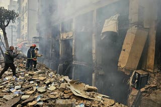 Spasioci se vide na mjestu izraelskog zračnog napada u južnom predgrađu Beiruta Haret Hreik 15. ožujka 2026.